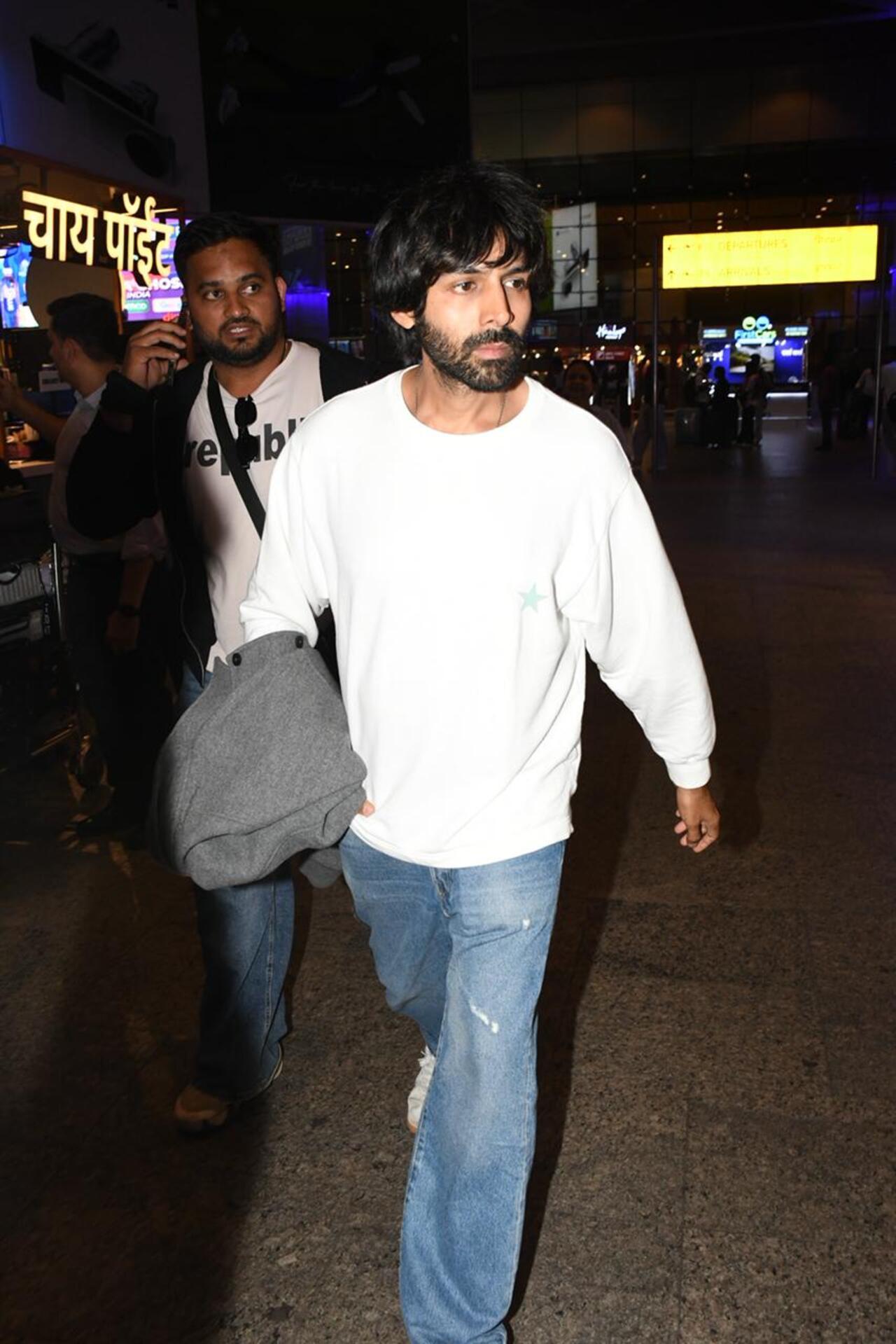 Kartik Aaryan was snapped at the airport in an easy-going travel look. Dressed in an oversized white sweatshirt and distressed blue denims, the actor carried a grey jacket.